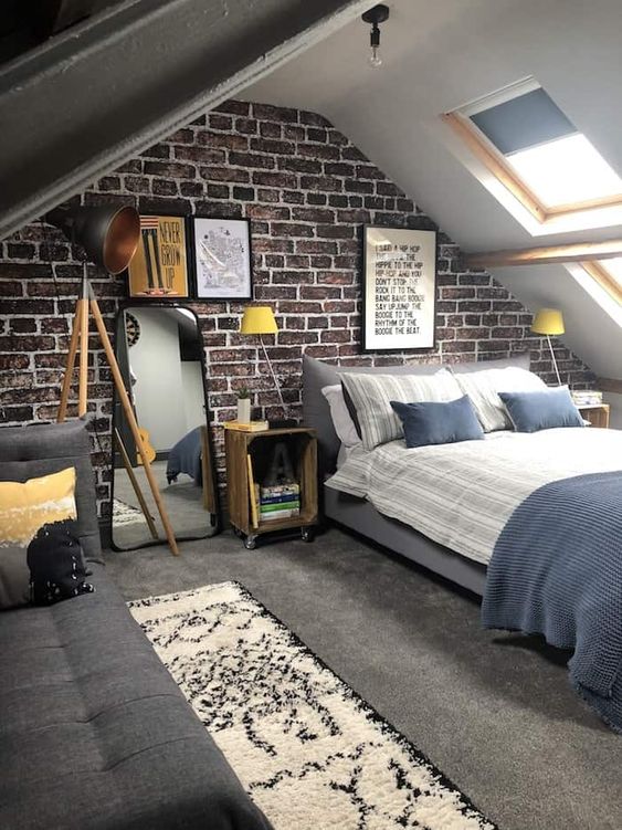 industrial style loft conversion with tripod floor lamp and exposed brick wall