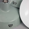 a 1950s mint green enamel industrial pendant light by REVO on a grey background.