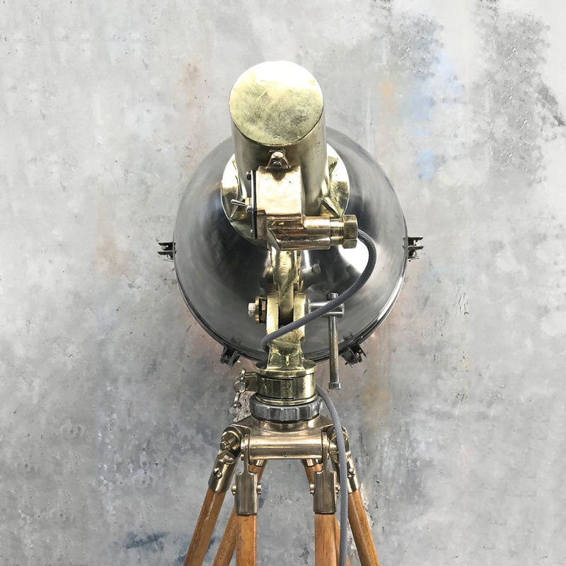 Shop our tall industrial floor lamp. A reclaimed stainless steel & brass searchlight  paired with a wooden tripod to create a bespoke tall floor lamp