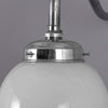 A 1950s milk glass globe wall light with polished aluminium swan neck wall mount.
