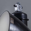 a large black enamel factory light hanging from the ceiling. reclaimed and restored for modern use. Manufactured during the 1960s by Elektrosvit