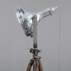 A tall tripod floor lamp comprising a cast aluminium flood light by GEC fitted to a WW2 telescopic hardwood tripod