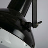 Black vitreous enamel vintage industrial pendant light with adjustable arm to tilt the illumination.