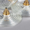 small glass ceiling lights with a brass hanging gallery. The circular glass shades have concentric circular pattern.