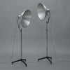 Two large vintage studio lights on stands against a gray background
