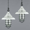 Two white vintage industrial ceiling lights with black cages which covered the glass dome over the lampholder.