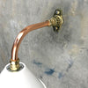 A white cantilever wall light with copper & brass wall fixture