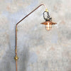 An extending wall light comprising a reclaimed industrial copper and iron cage light pendant extending from the wall by a copper pipe which can be made to length.