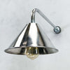 an industrial style aluminium wall light. It has a conical shaped aluminium lamp shade which is attached to a curved galvanised steel wall arm making this a wall mounted down light ideal for illuminating pictures on the wall or adding ambience alongside ceiling lights.