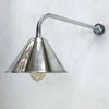 an industrial style aluminium wall light. It has a conical shaped aluminium lamp shade which is attached to a curved galvanised steel wall arm making this a wall mounted down light ideal for illuminating pictures on the wall or adding ambience alongside ceiling lights.