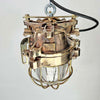 An industrial bronze ceiling light with a brass cage covering a tempered glass dome reclaimed from old ships and restored for modern interiors. Worldwide shipping is available. 15 of these fixtures are available for sale.