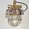 An industrial bronze ceiling light with a brass cage covering a tempered glass dome reclaimed from old ships and restored for modern interiors. Worldwide shipping is available. 15 of these fixtures are available for sale.