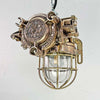 An industrial bronze ceiling light with a brass cage covering a tempered glass dome reclaimed from old ships and restored for modern interiors. Worldwide shipping is available. 15 of these fixtures are available for sale.