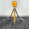 Brass searchlight floor lamp. Reclaimed and restored brass searchlight paired with a wooden tripod and has a floor switch