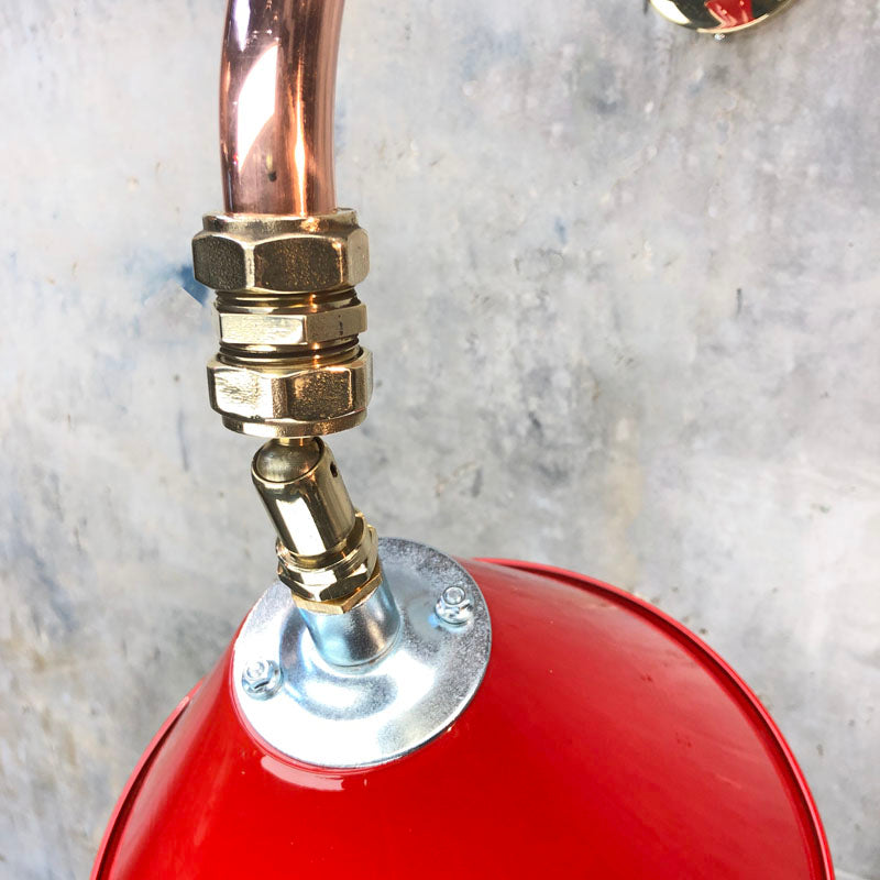 A cantilever wall light comprising a directional red lamp shade which is attached to a copper and brass wall arm fixture. The red shade is attached via a ball joint so rotates in all directions making this a great directional wall light. 