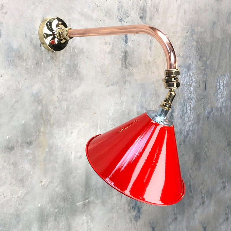 A cantilever wall light comprising a directional red lamp shade which is attached to a copper and brass wall arm fixture. The red shade is attached via a ball joint so rotates in all directions making this a great directional wall light. 