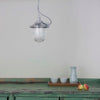 Vintage industrial Aluminium pendant light with prismatic glass shade hanging over a rustic green sideboard