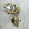 Outdoor explosion proof brass wall light with switch. Restored lighting with protective cage