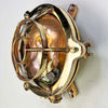 Reclaimed and restored vintage industrial brass bullseye bulkhead wall light. Featuring a bullseye style cage to protect the lamp holder.