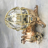 This robust bronze wall light is an original flameproof industrial lamp which has been restored for a modern interiors. It features a brass cage and all the original manufacturers castings on the plate