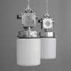 Pair of industrial-style pendant lights with metal fixtures and white opaline glass against a gray background