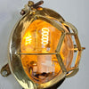 A brass industrial round bulkhead light with a protective hexagonal cage. Sometimes described as a bullseye lamp due to the design of the cage this original vintage brass wall light is reclaimed from marine environments and professionally refurbished and rewired by hand in our workshop ready for indoor use