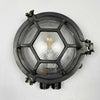 The industrial bulkhead light is a robust reclaimed industrial round wall light featuring a hexagonal cast aluminium cage and chevron reeded glass which diffuses the illumination beautifully. It is industrial lighting at its best, made for use on cargo ships and supertankers where they were used to illuminate passageways. We professionally restore each fixture by hand to British safety standards ready for contemporary interiors