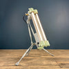 A green T8 steampunk floor lamp on a tripod. It is a reclaimed industrial flameproof tube light circa 1976 fitted to a steampunk style tripod