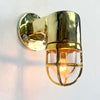 Shop for a small brass nautical wall light. Reclaimed from old ships and restored. This small vintage wall light features a brass cage and tempered glass which covers and protects the lamp holder. Can be used both as small indoor lighting or small outdoor lighting