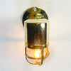 Shop for a small brass nautical wall light. Reclaimed from old ships and restored. This small vintage wall light features a brass cage and tempered glass which covers and protects the lamp holder. Can be used both as small indoor lighting or small outdoor lighting