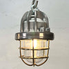 small reclaimed ceiling cage lights in aluminium and brass hanging over a rustic dining table. Suitable to use as kitchen or bathroom lighting