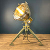 Shop for a steampunk style floor lamp. Comprised of a searchlight which has been expertly modified to integrate seamlessly with the tripod, secured by three brass thumb screws for stability and functionality. A cast brass Wiska rotary marine isolator switch provides a reliable and straightforward mechanism for operating the lamp.