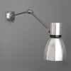A Czechoslovakian wall-mounted vintage industrial cantilever wall lamp with adjustable arm on a gray background made by Elektrosvit