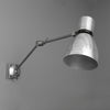 A Czechoslovakian wall-mounted vintage industrial cantilever wall lamp with adjustable arm on a gray background made by Elektrosvit
