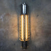 A vintage industrial caged wall strip light restored with T8 LED tubes mounted vertically on a concrete wall.