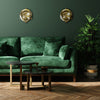 Vintage industrial brass bulkhead wall lighting refurbished, mounted on a living room wall with dark green wall, green velvet sofa and large green plant. Modern industrial style living room