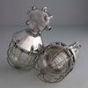Two metallic industrial lights with cage designs on a grey background made in POland in 1970's