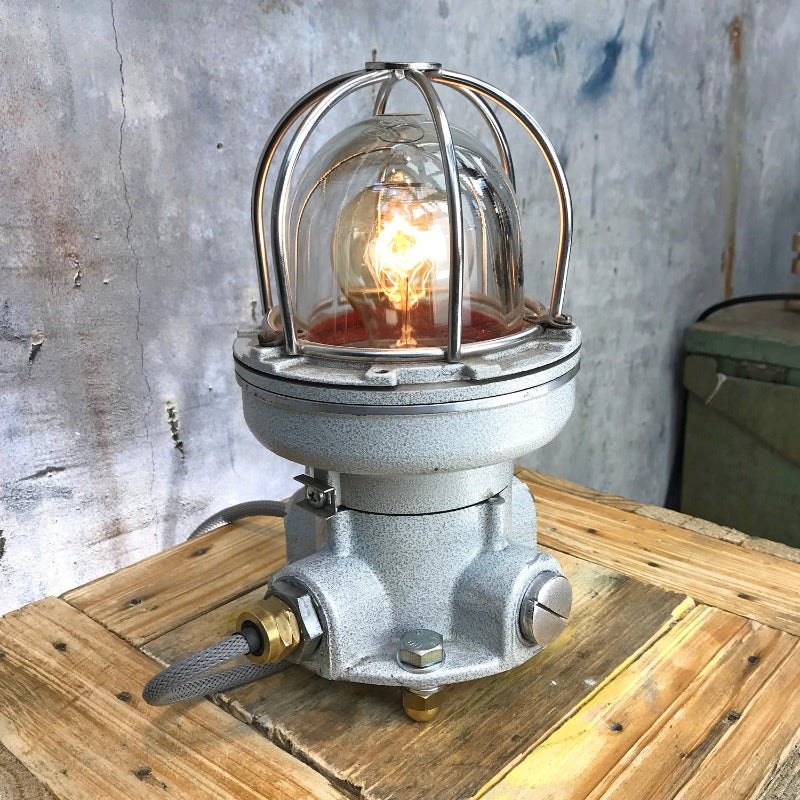 An industrial style cage table lamp in grey with filament bulb and braided cable. An authentic reclaimed industrial lamp.
