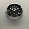 Silver wall clock with black face and white digits. This original nautical wall clock features a quartz silent sweep seconds hand movement meaning no ticking! a timeless and silent wall clock suitable for any contemporary interior.