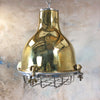 A vintage brass dome ceiling pendant light fixture with an aluminium industrial style cage.