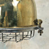 A vintage brass dome ceiling pendant light fixture with an aluminium industrial style cage.