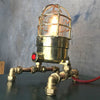 A vintage industrial 1970's brass explosion proof passage way light modified into a steampunk style table lamp.