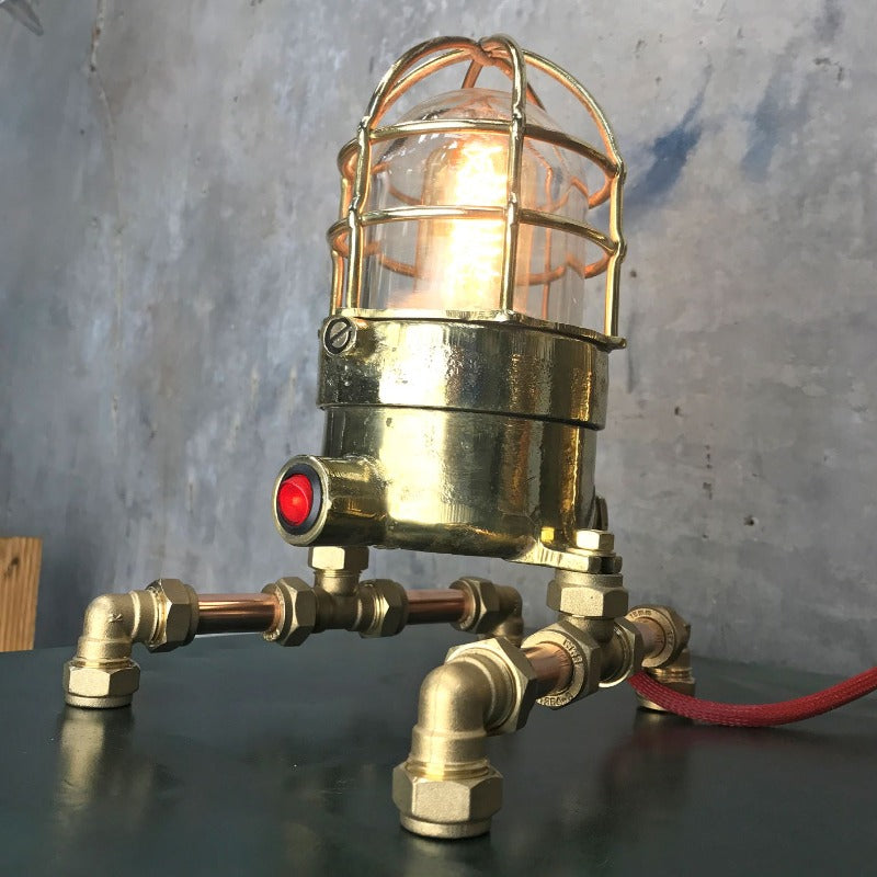 A vintage industrial 1970's brass explosion proof passage way light modified into a steampunk style table lamp. 