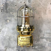 A retro industrial brass outdoor wall light with protective glass shade and cage