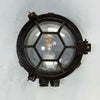 Black iron wall light with cage and prismatic glass cover. The round bulkhead is reclaimed and restored for modern interiors compatible with LED light bulb.