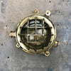 A small vintage industrial cast bass and glass circular bulkhead wall light