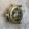 A small vintage industrial cast bass and glass circular bulkhead wall light