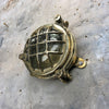 A small vintage industrial cast bass and glass circular bulkhead wall light