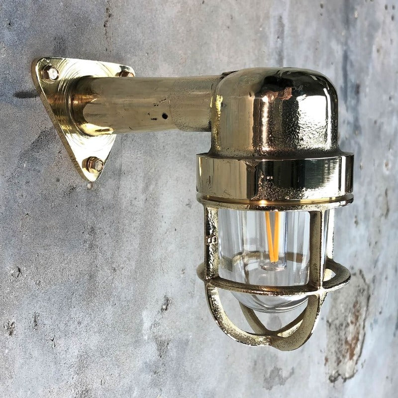 A reclaimed retro industrial solid brass 90 degree outdoor wall light with protective cage. 
