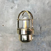 A reclaimed retro industrial solid brass 90 degree outdoor wall light with protective cage.
